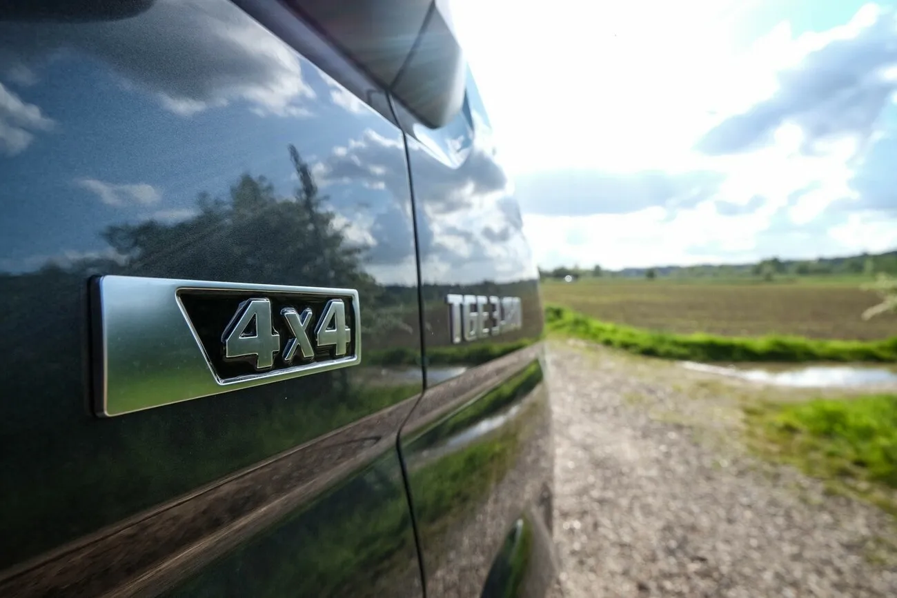 Nahaufnahme der Beschriftung "4x4" an der Fahrzeugseite des MAN TGE 3180 4x4.