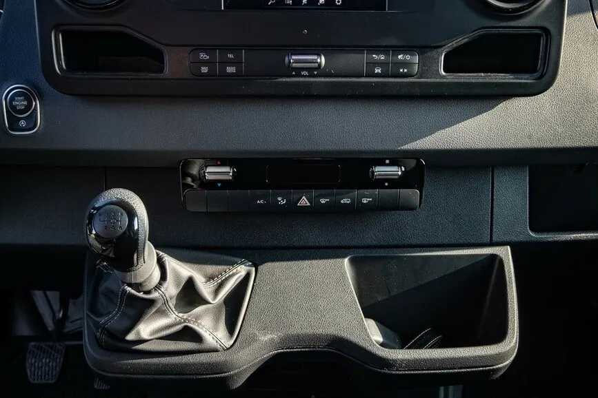 Innenansicht des Mercedes Benz Sprinters zeigt eine Nahaufnahme, welche die Gangschaltung und das Armaturenbrett fokussiert.