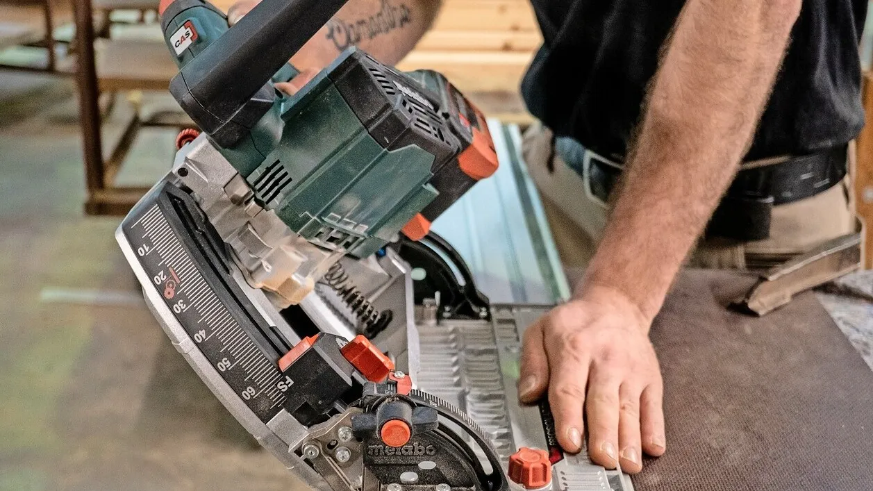 Ausschnitt von einem Mann, der die Metabo Tauchsäge KT 18 LTX 66 BL testet.