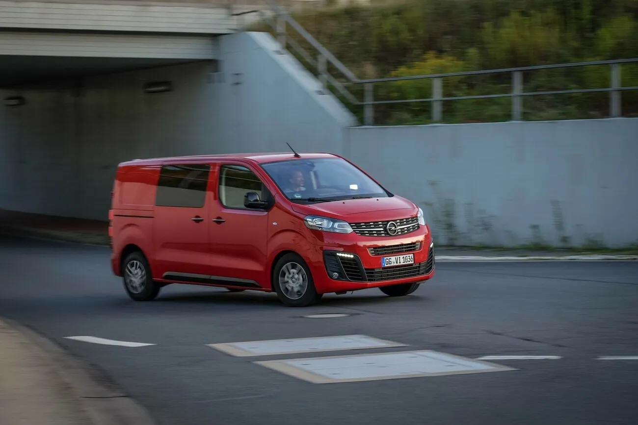 Der rote Opel Vivaro Doka fährt unter einer Brücke raus.