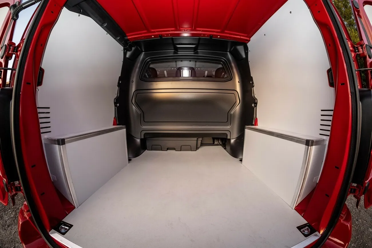 Der rote Opel Vivaro Doka von innen, mit Blick auf den Ladebereich aus Perspektive der Vordersitze.