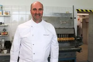 Florian Mangold vor der Baumkuchenmaschine des Betriebs, die schon vor 40 Jahren von seinem Schwiegervater angeschafft wurde.