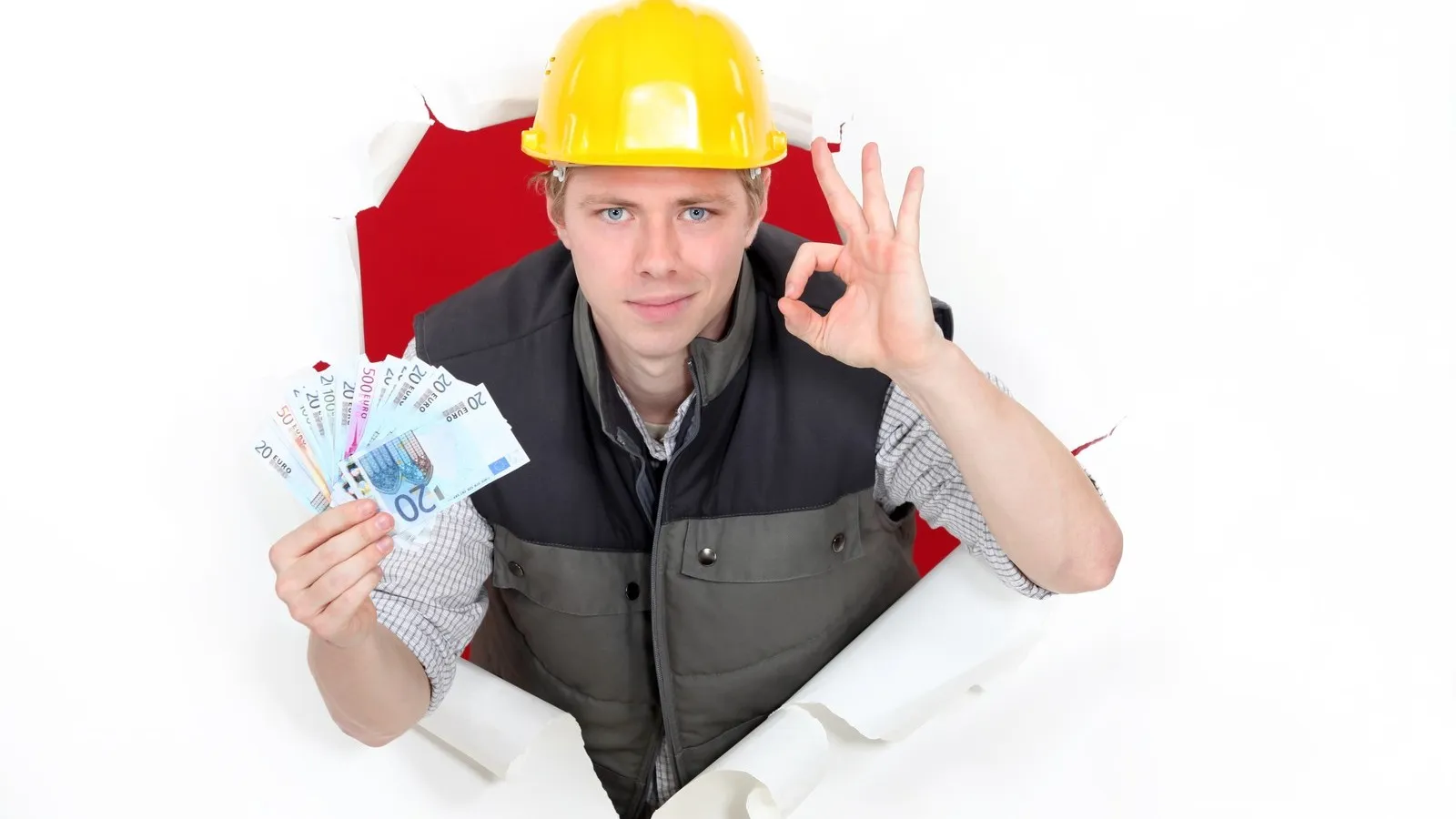 Ein Mann mit einem gelben Schutzhelmbeugt sich aus einer aufgerissenen Wand. In der einen Hand hält er mehrere Euro-Scheine und mit der anderen signalisiert er ein "ok".