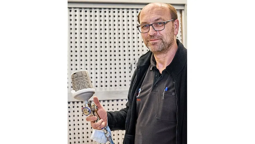 Foto von Tischlermeister Kai Wehrhahn mit der Lackierpistole in der Hand.