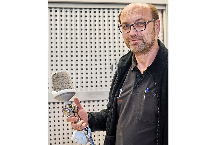 Foto von Tischlermeister Kai Wehrhahn mit der Lackierpistole in der Hand.