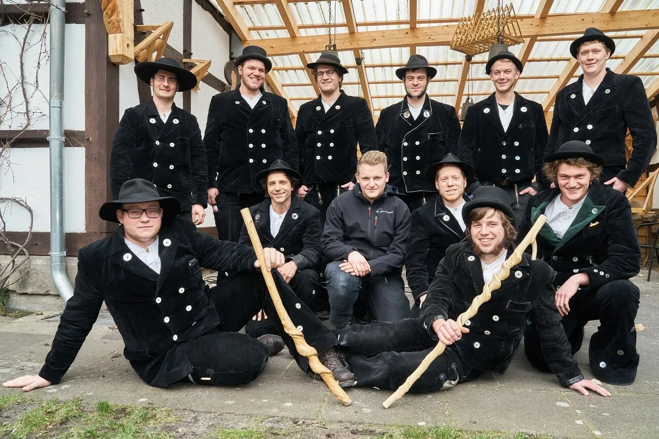 Gruppenfoto der Wandergesellen in ihrer Zunftkleidung.