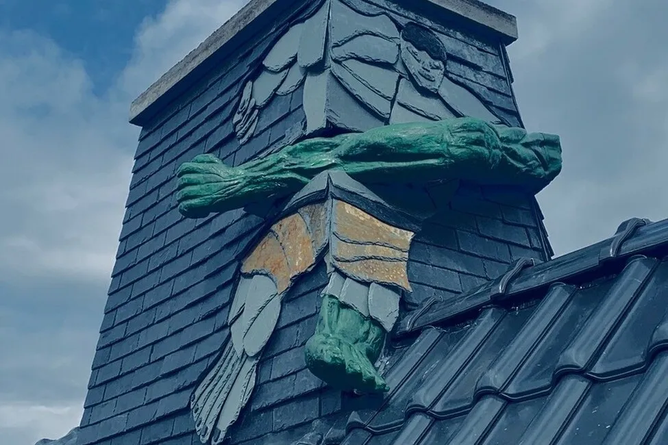 Eine in das Dach eines Hauses eingearbeitete Schieferkunst in Form des bekannten Hulk.