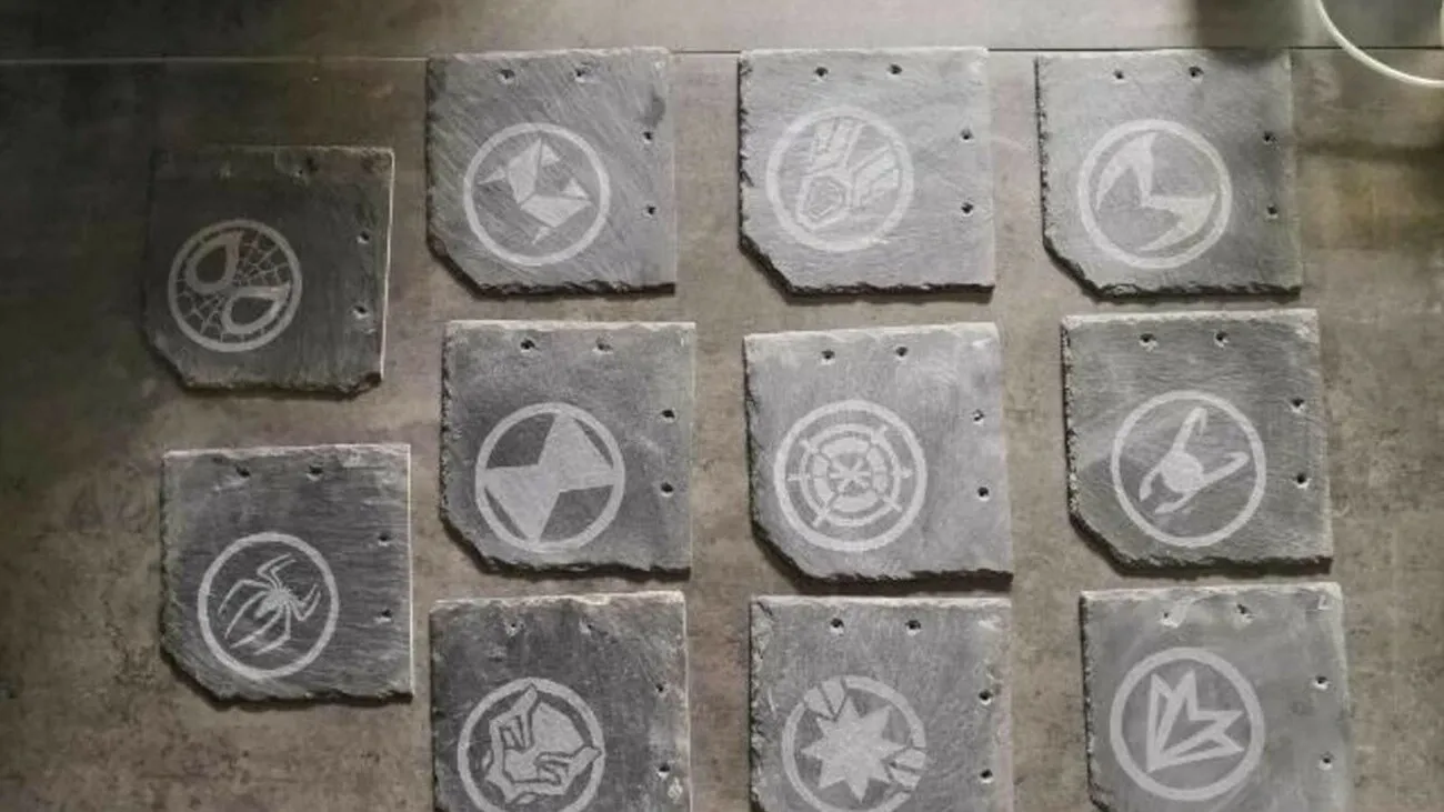 Elf Steinplatten sind in dreier Reihen nebeneinander platziert. Darauf sind Comic Symbole zu sehen.