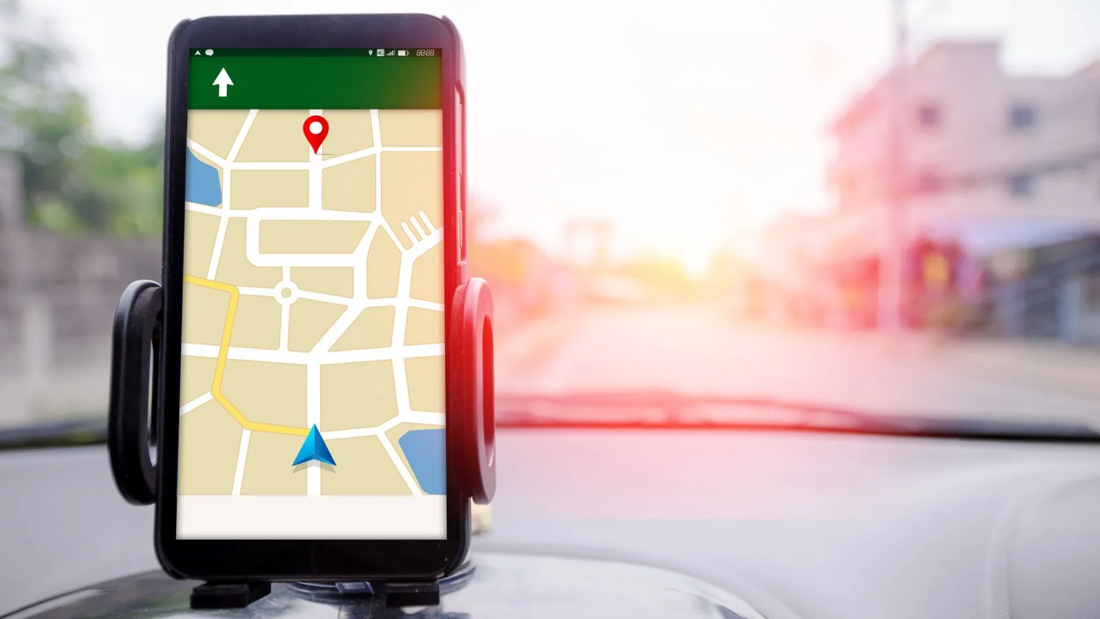 Ein Handy wurde in einem Auto über der Mittelkonsole angebracht und zeigt eine Strecke bei Google Maps.