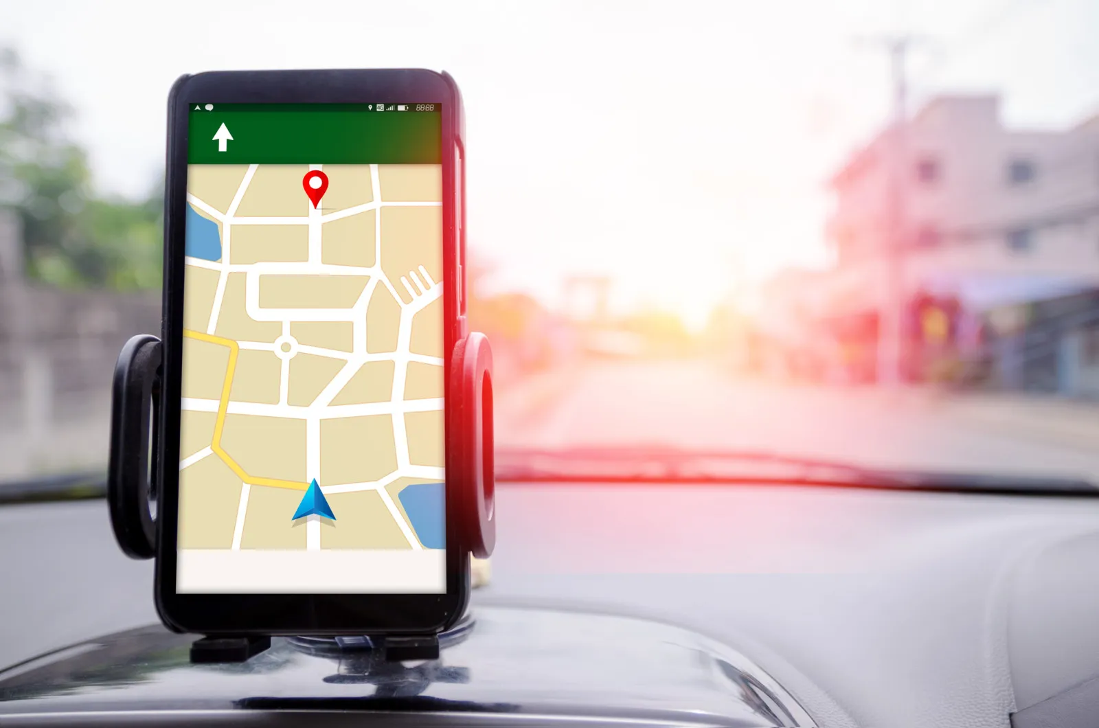 Ein Handy wurde in einem Auto über der Mittelkonsole angebracht und zeigt eine Strecke bei Google Maps.