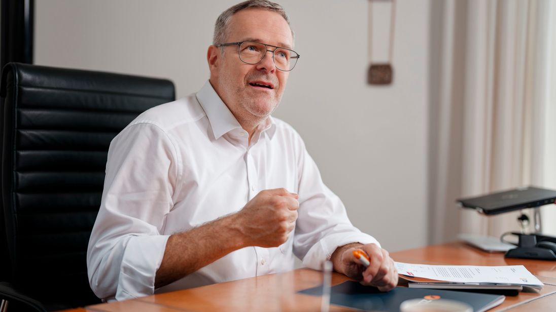 ZDH-Präsident Jörg Dittrich sitzt an einem Schreibtisch und spricht.