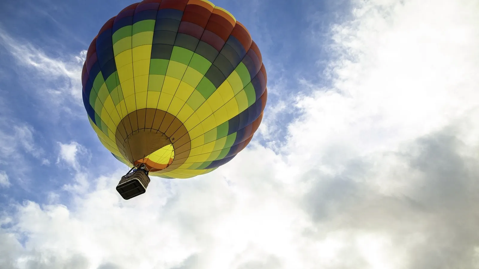 Aus der Froschperspektive: Ein bunter Heißluftballon steigt in den Himmel auf.