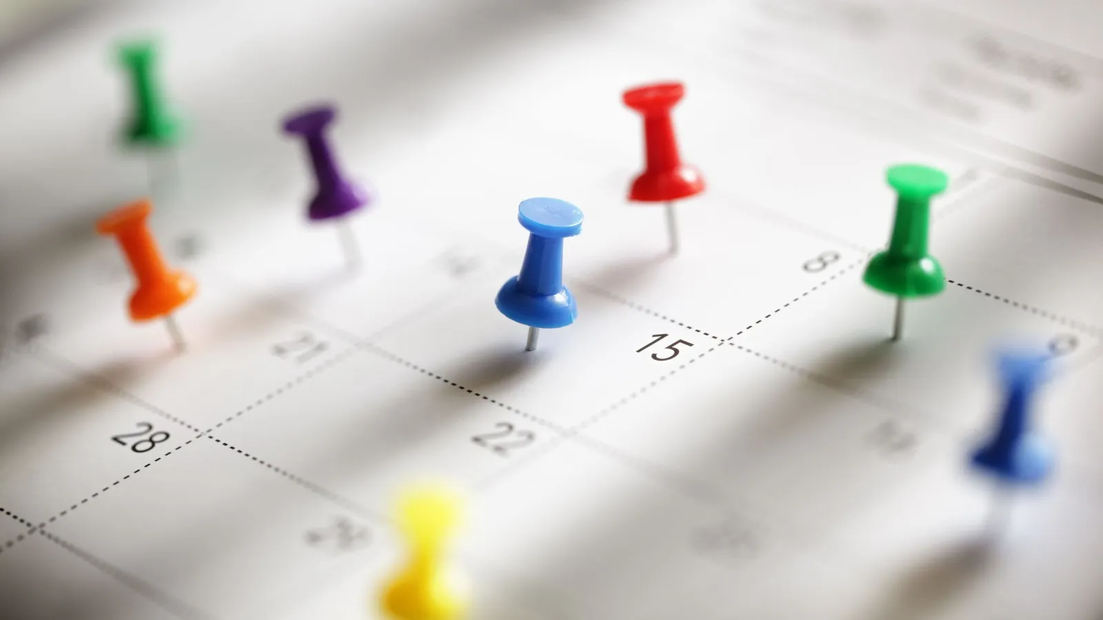 Ein Kalender auf den Stecknadeln in verschiedenen Farben gepinnt sind.