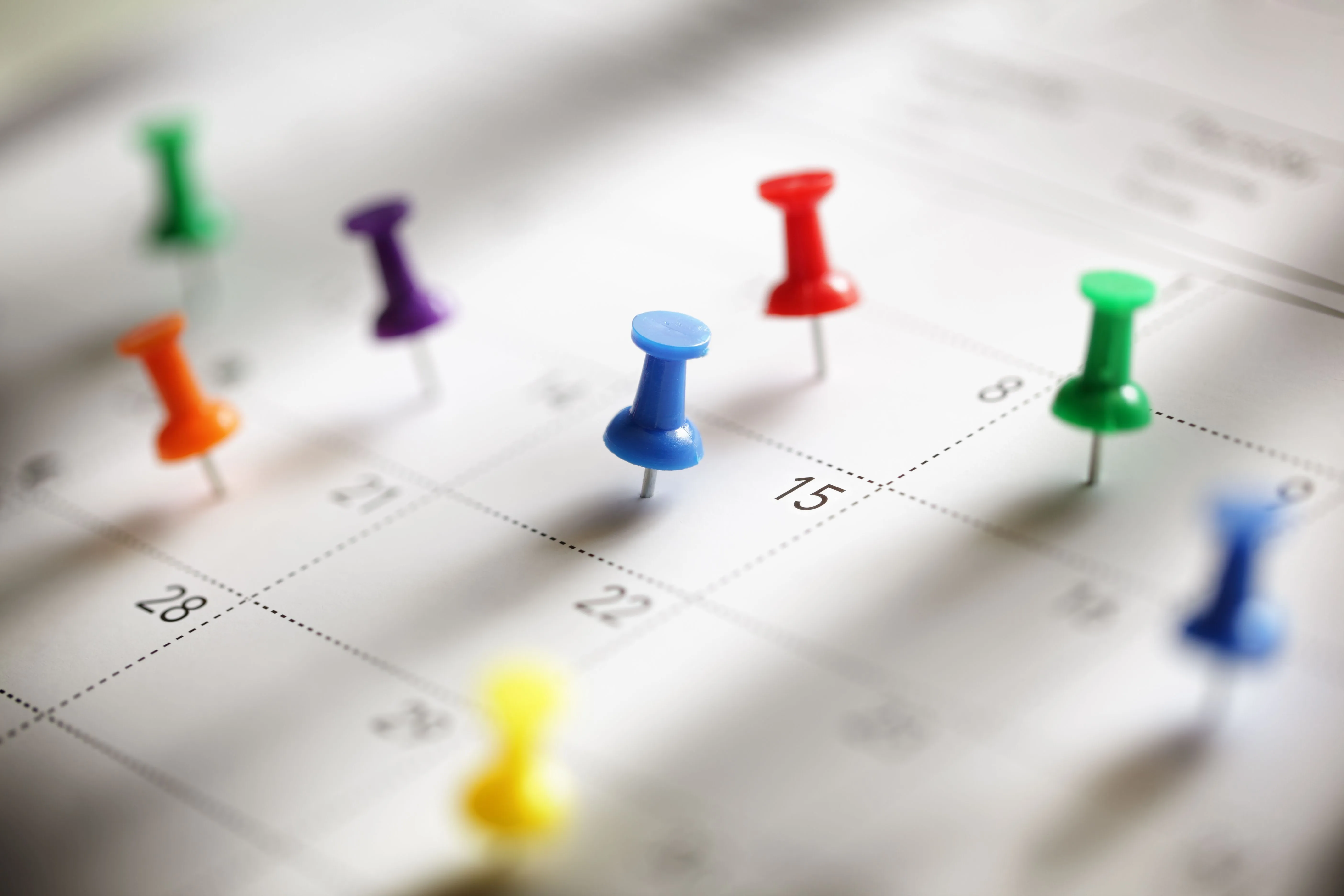 Ein Kalender auf den Stecknadeln in verschiedenen Farben gepinnt sind.