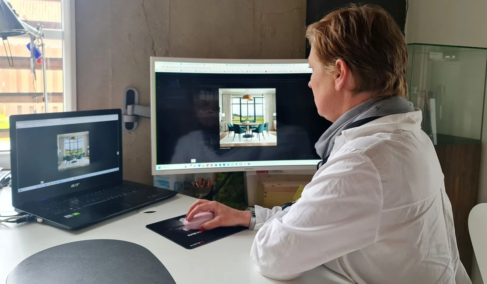 Anke Freund sitzt an einem Schreibtisch am PC und erstellt Bild-Entwürfe.