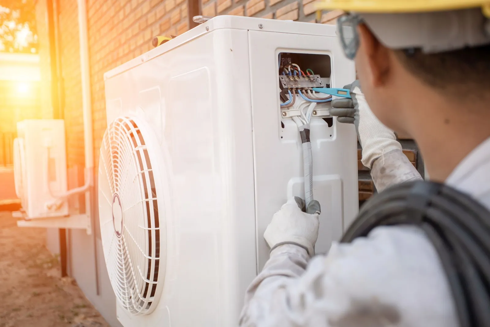 Ein Handwerker montiert eine Wärmepumpe.