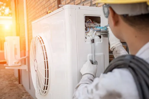 Ein Handwerker montiert eine Wärmepumpe.