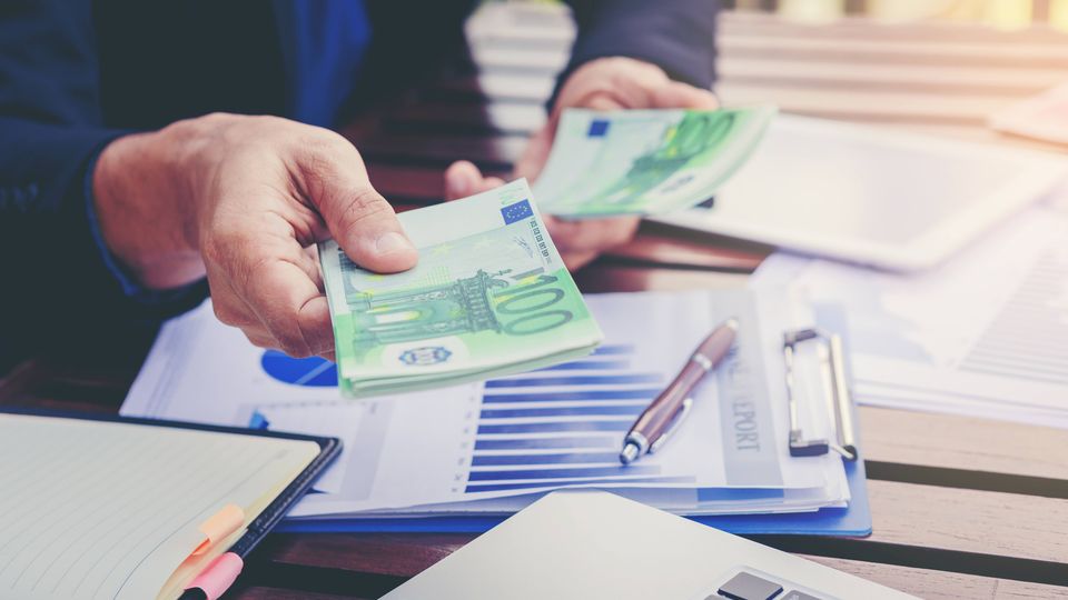 Im Büro wird die Anzahlung für einen Auftrag bar gezahlt.