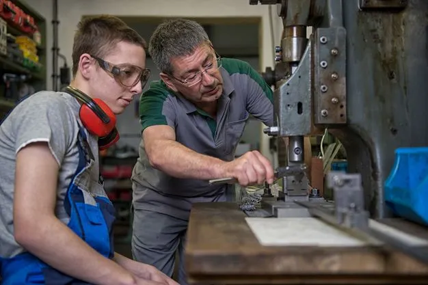 Ausbilder und Azubi im Handwerk an einer Maschine