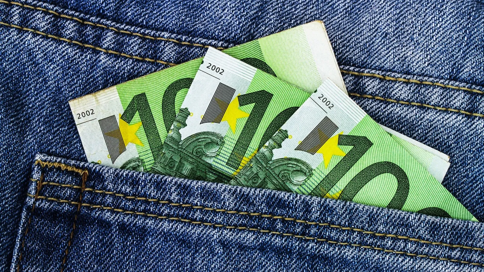 Drei 100-Euro Scheine in einer Jeanshosentasche.