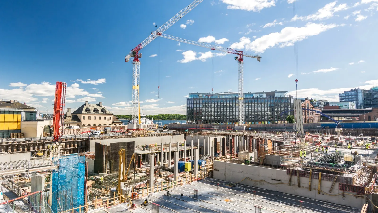 Blick auf eine große Baustelle mit einem Kran und einem Gebäude im Hintergrund.