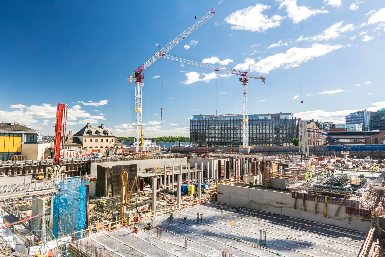 Blick auf eine große Baustelle mit einem Kran und einem Gebäude im Hintergrund.