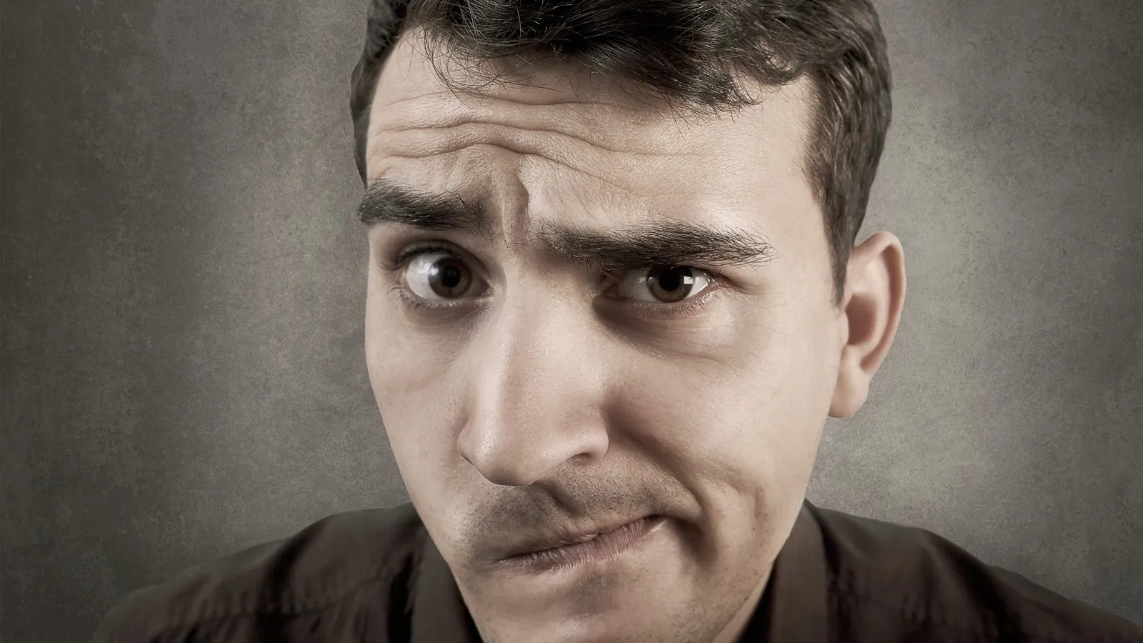 Ein Mann mit einem unentschiedenen skeptischen Gesichtsausdruck.