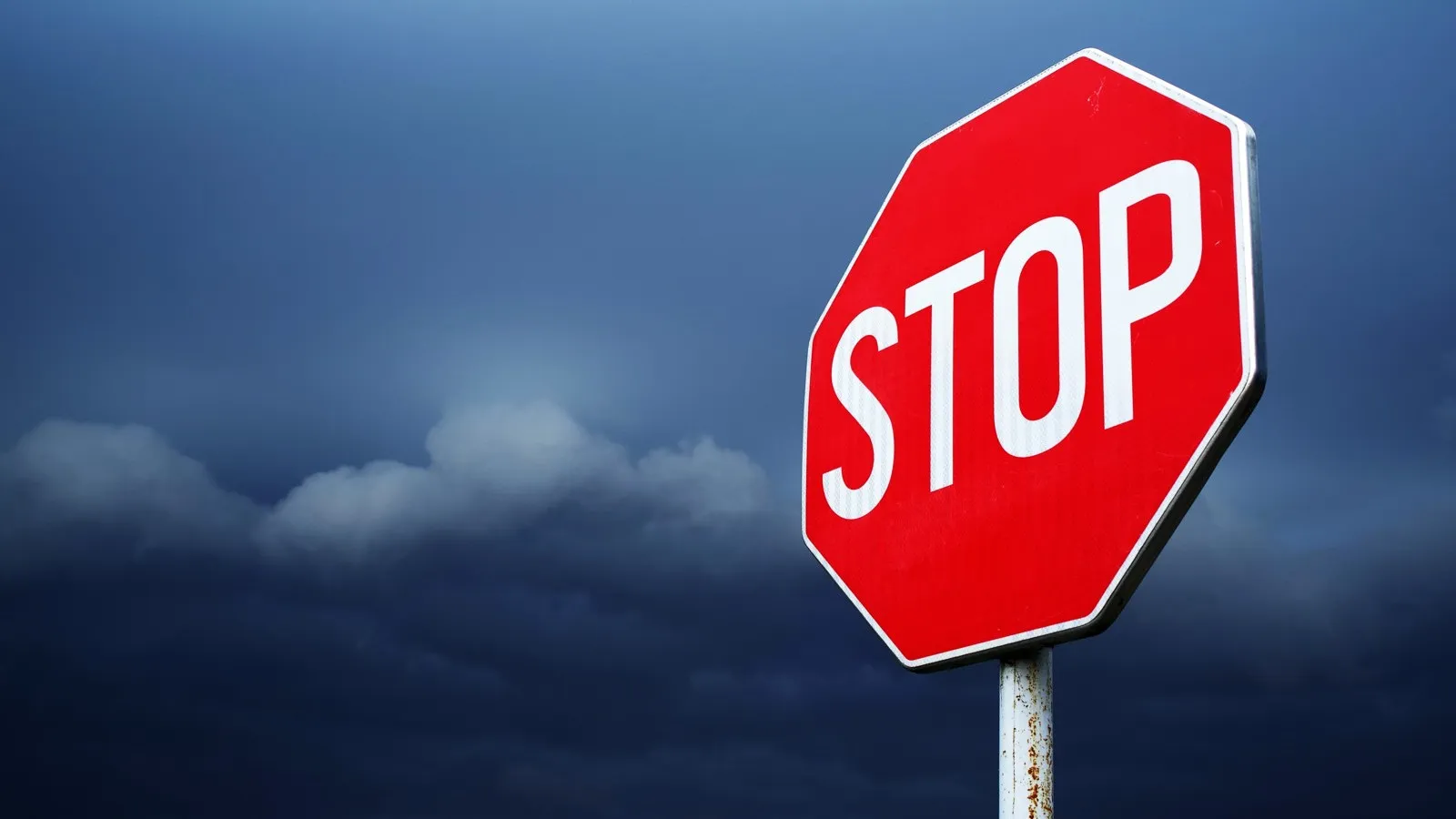 Ein Stoppschild vor einem dunklen Himmel.