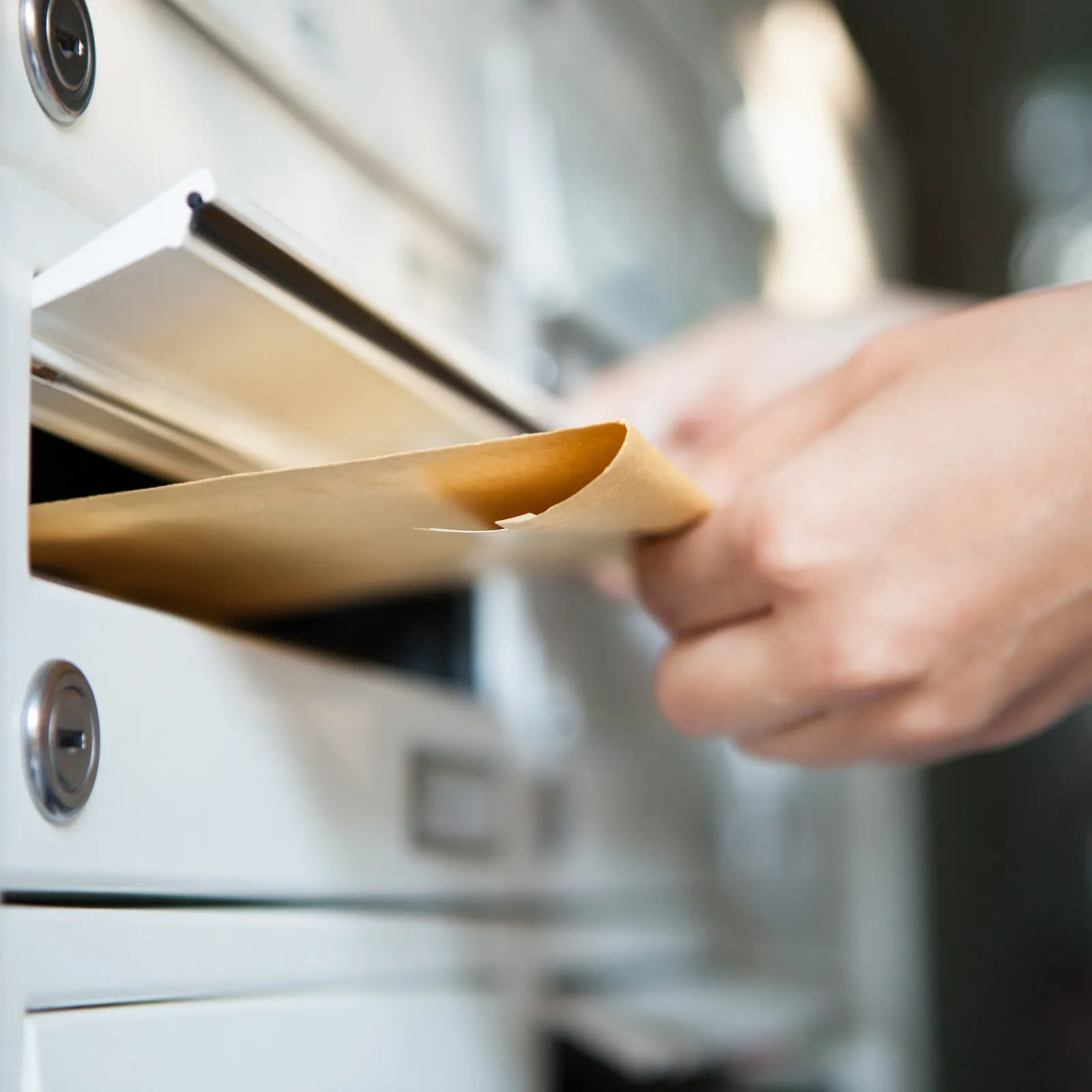 Ein Brief wird in den Briefkasten gesteckt.