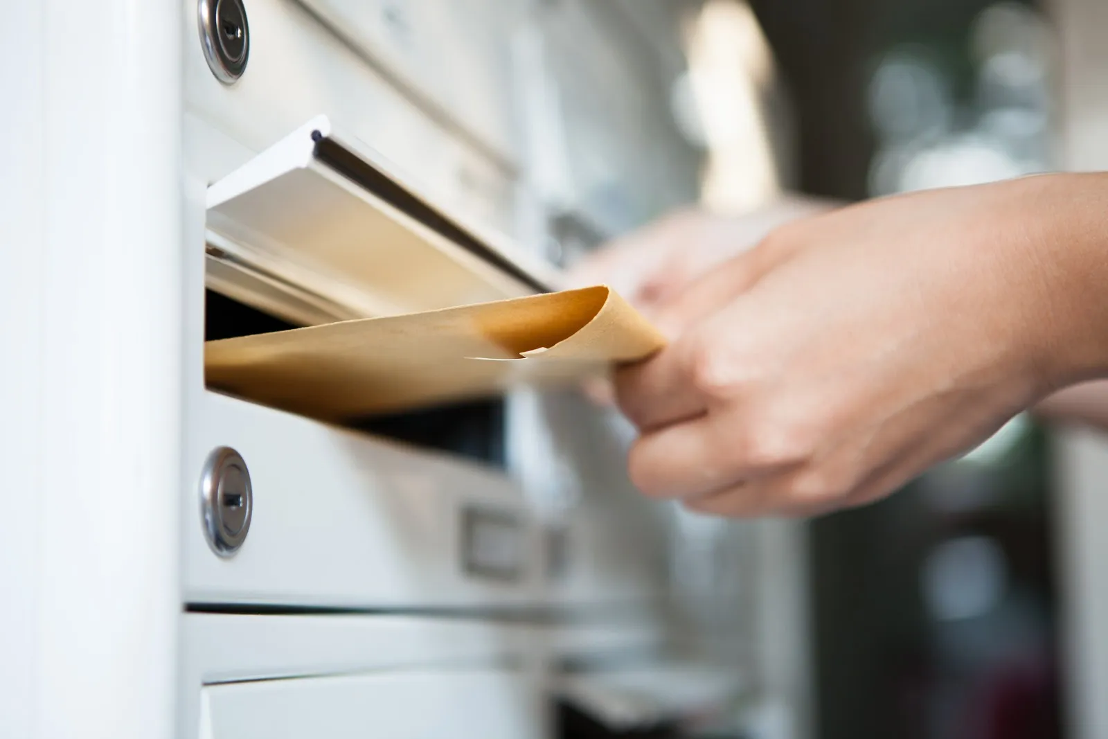 Ein Brief wird in den Briefkasten gesteckt.