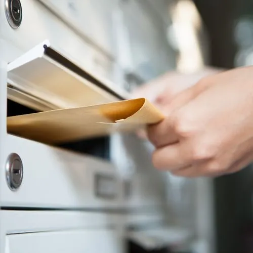 Ein Brief wird in den Briefkasten gesteckt.