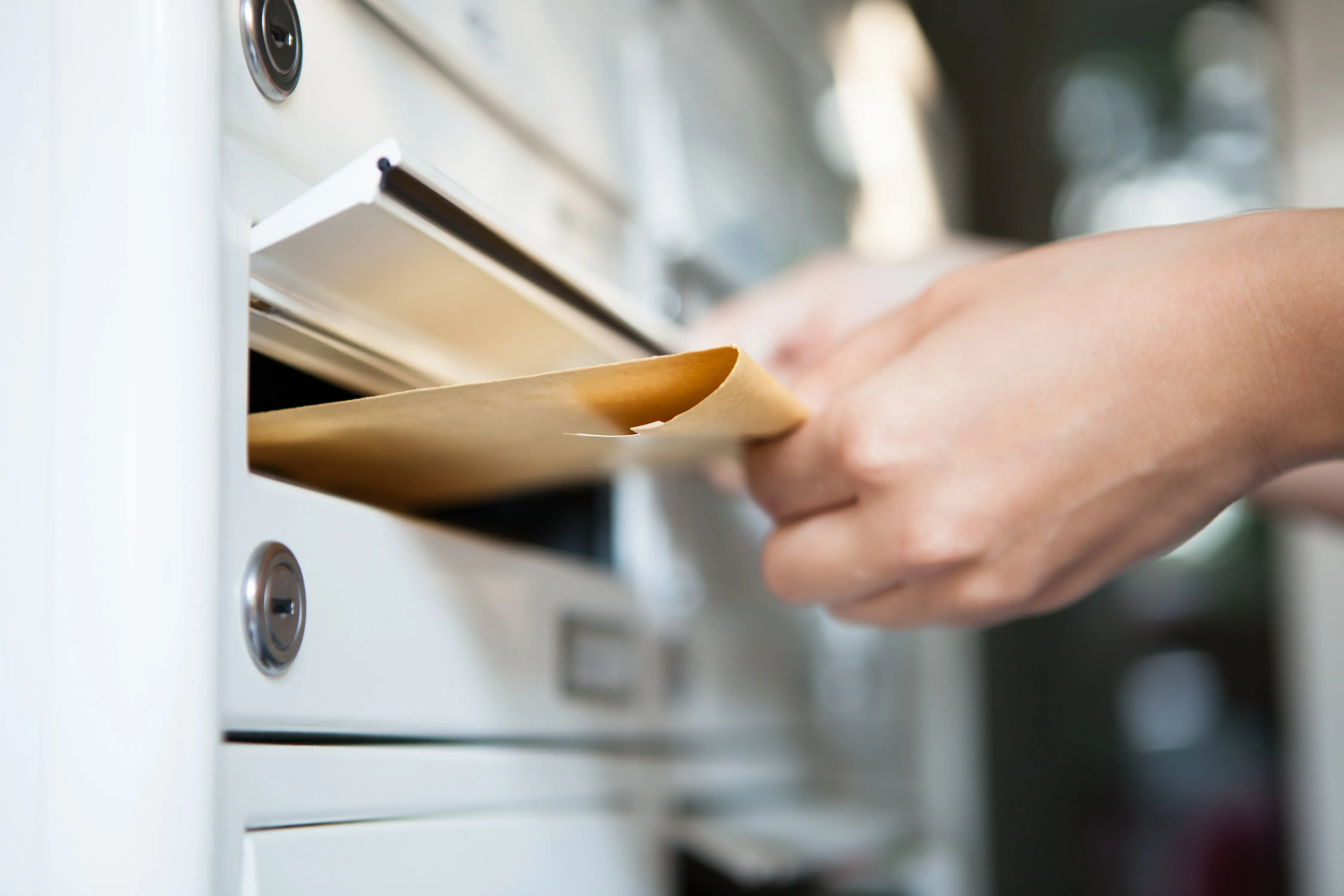 Ein Brief wird in den Briefkasten gesteckt.