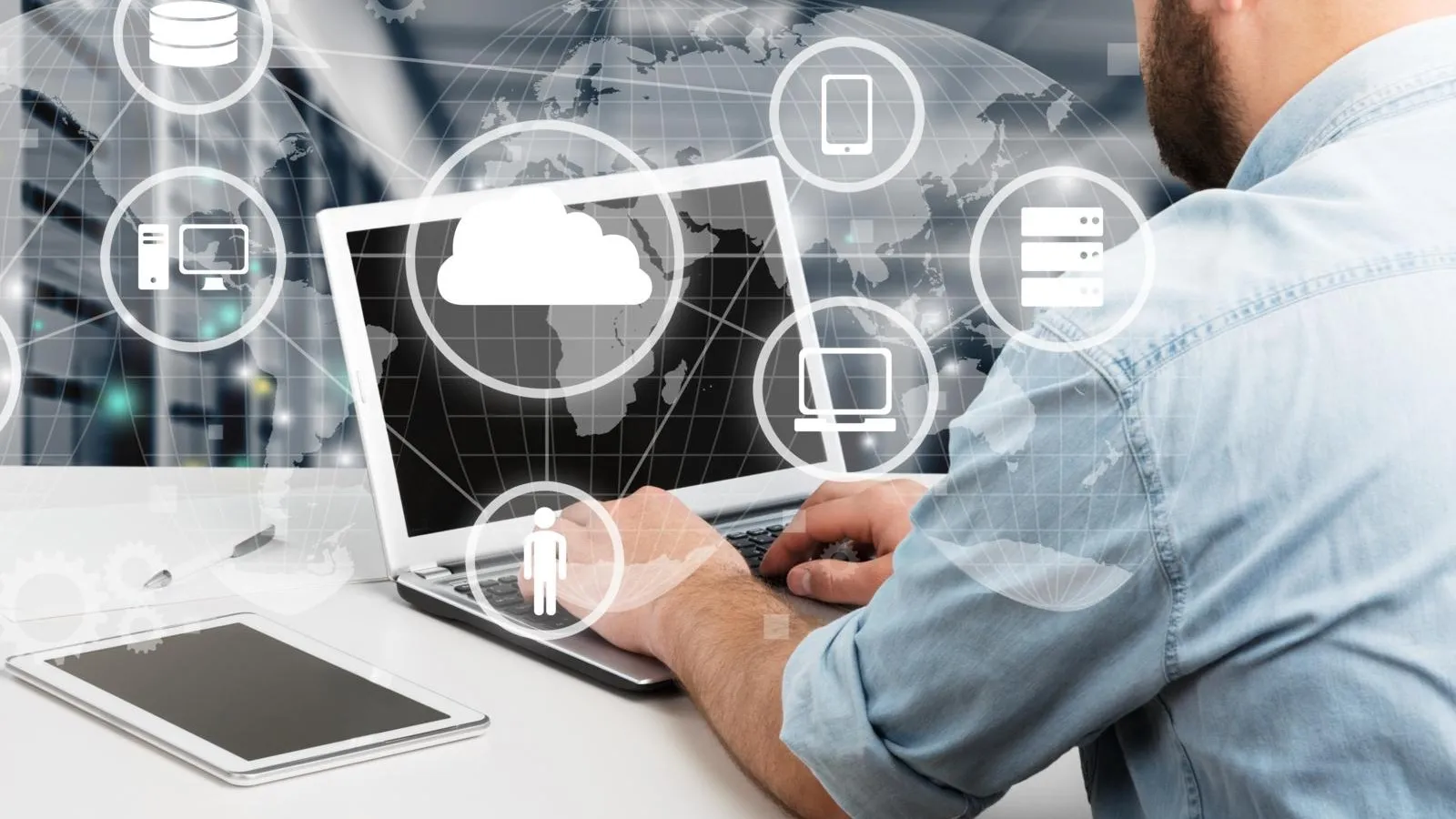 Ein Mann sitz vor dem Laptop. Davor sind Symbole von Cloud, Computer, Handy und Daten.