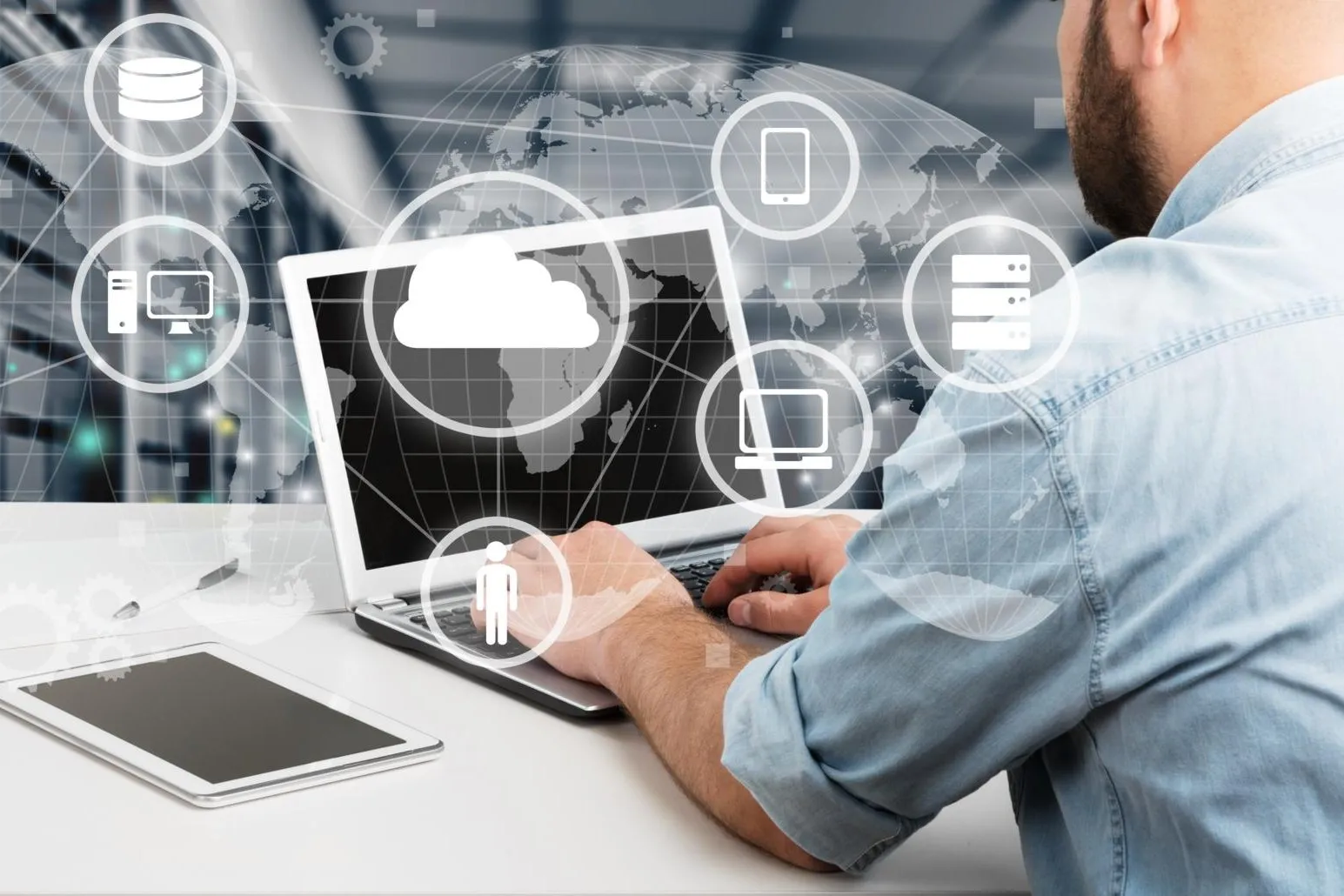 Ein Mann sitz vor dem Laptop. Davor sind Symbole von Cloud, Computer, Handy und Daten.