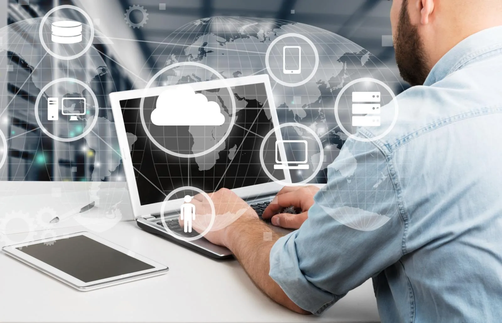 Ein Mann sitz vor dem Laptop. Davor sind Symbole von Cloud, Computer, Handy und Daten.