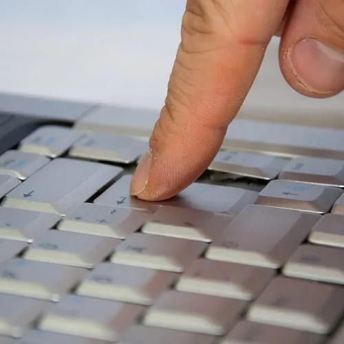 Finger drückt auf Enter-Taste