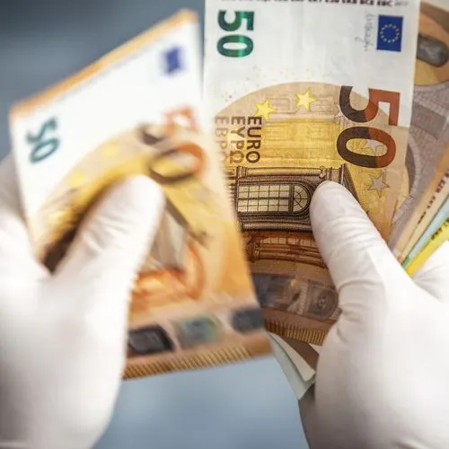 Hände mit Handschuhen halten Geldscheine