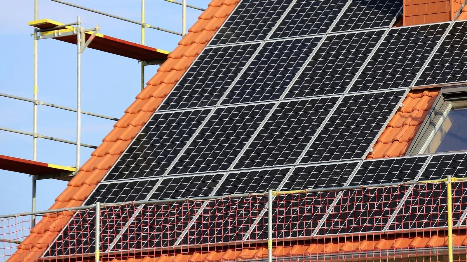 Ein Dach mit einer Solaranlage. Das Dach ist mit Netzen gesichert.