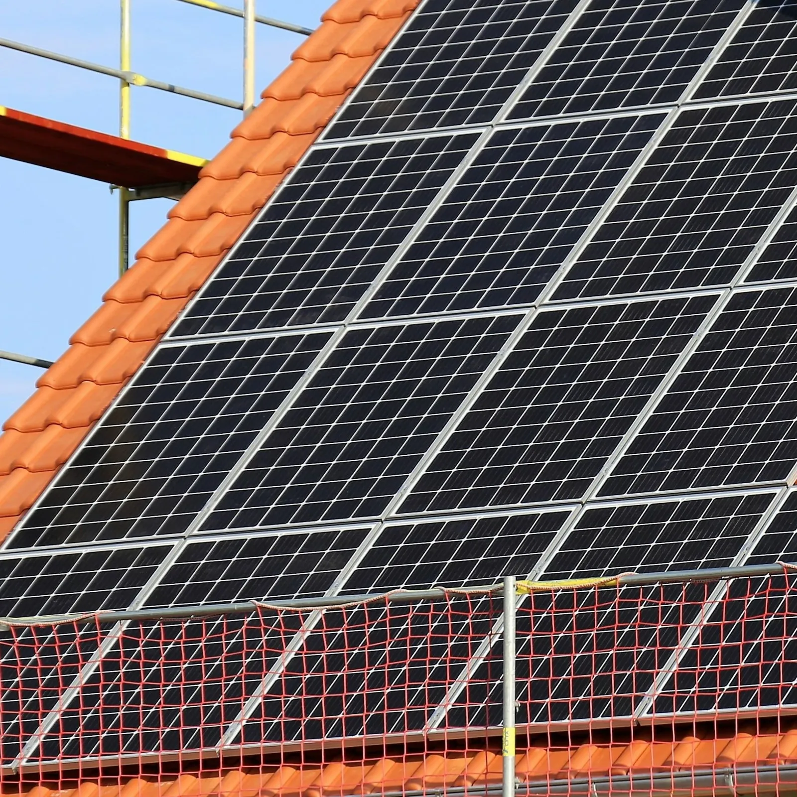 Ein Dach mit einer Solaranlage. Das Dach ist mit Netzen gesichert.