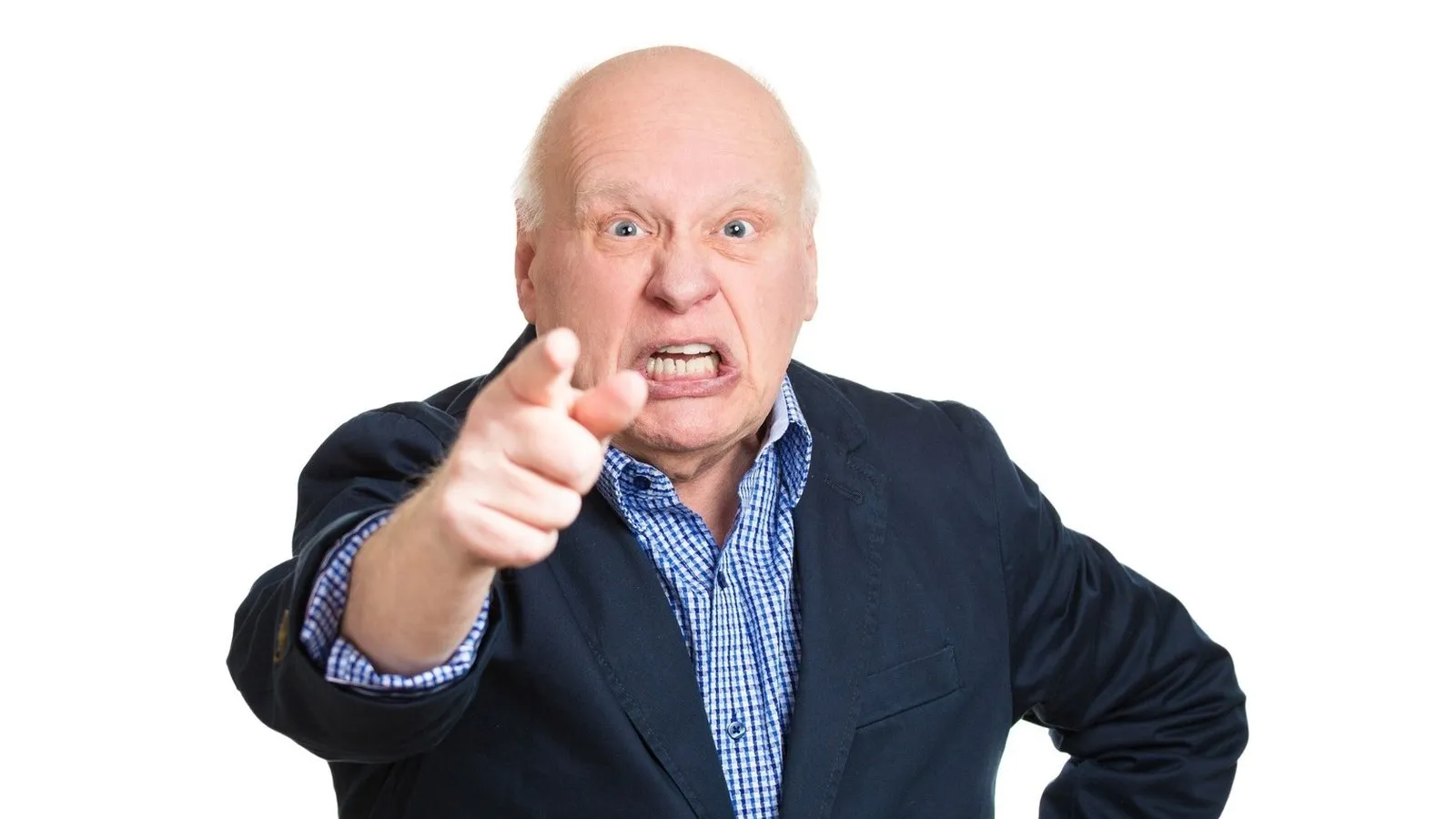 Ein älterer Mann in einer blauen Anzugsjacke vor einem weißen Hintergrund zeigt wütend mit dem Zeigefinger ins Bild.