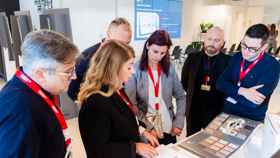Eine Gruppe von sechs Menschen schaut sich die neue Kollektion Dekorativ 26+ von Egger an.