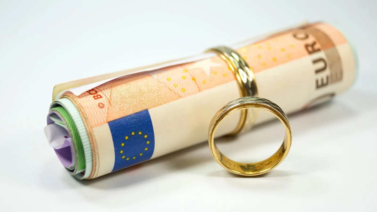 Eheringe und eine Rolle Geldscheine