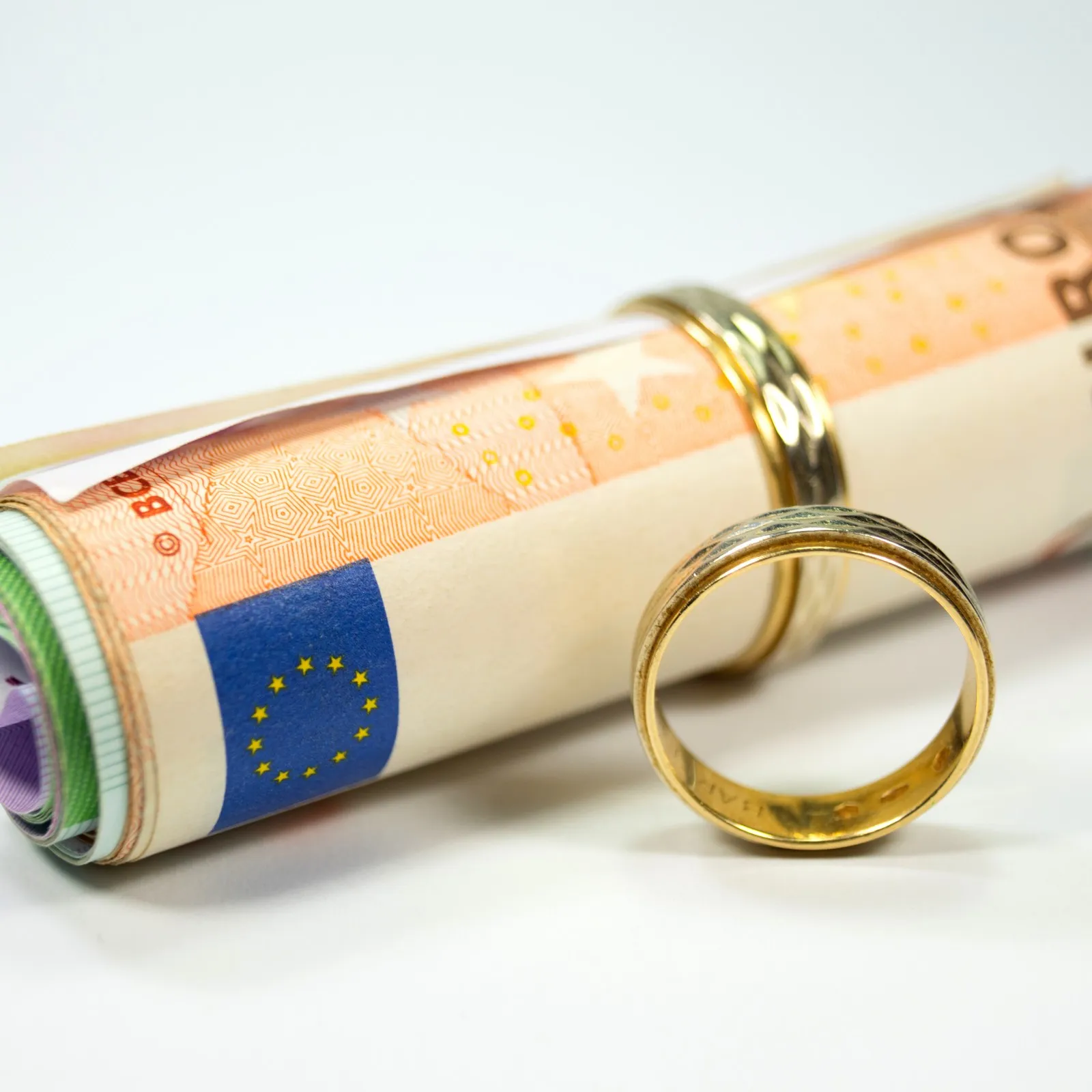Eheringe und eine Rolle Geldscheine