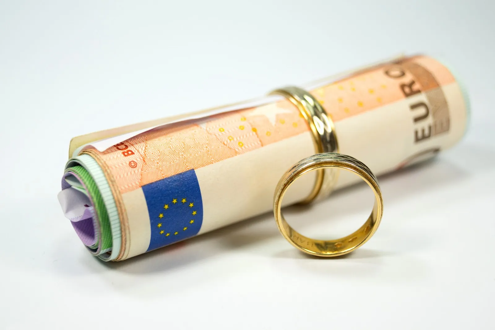 Eheringe und eine Rolle Geldscheine