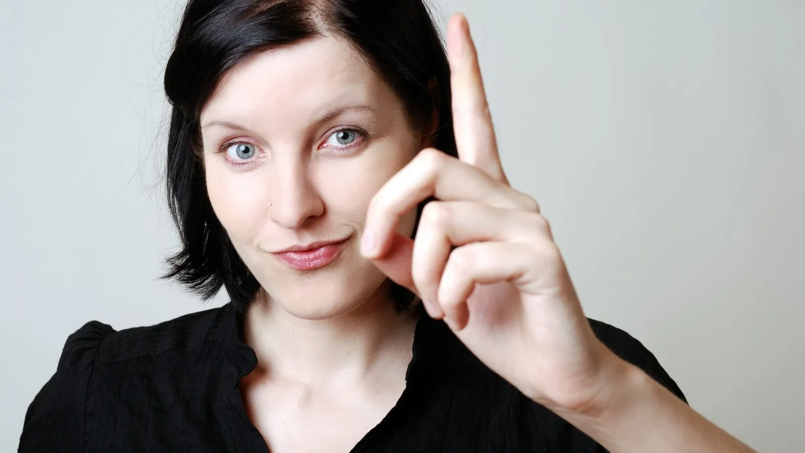 Frau erhebt ihren Zeigefinger.