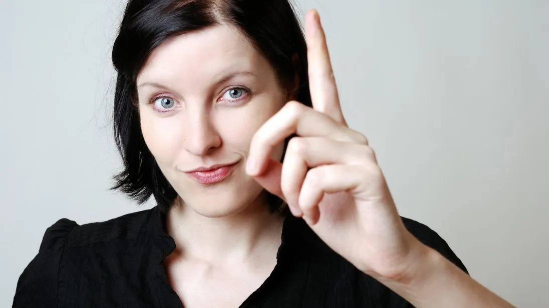 Frau erhebt ihren Zeigefinger