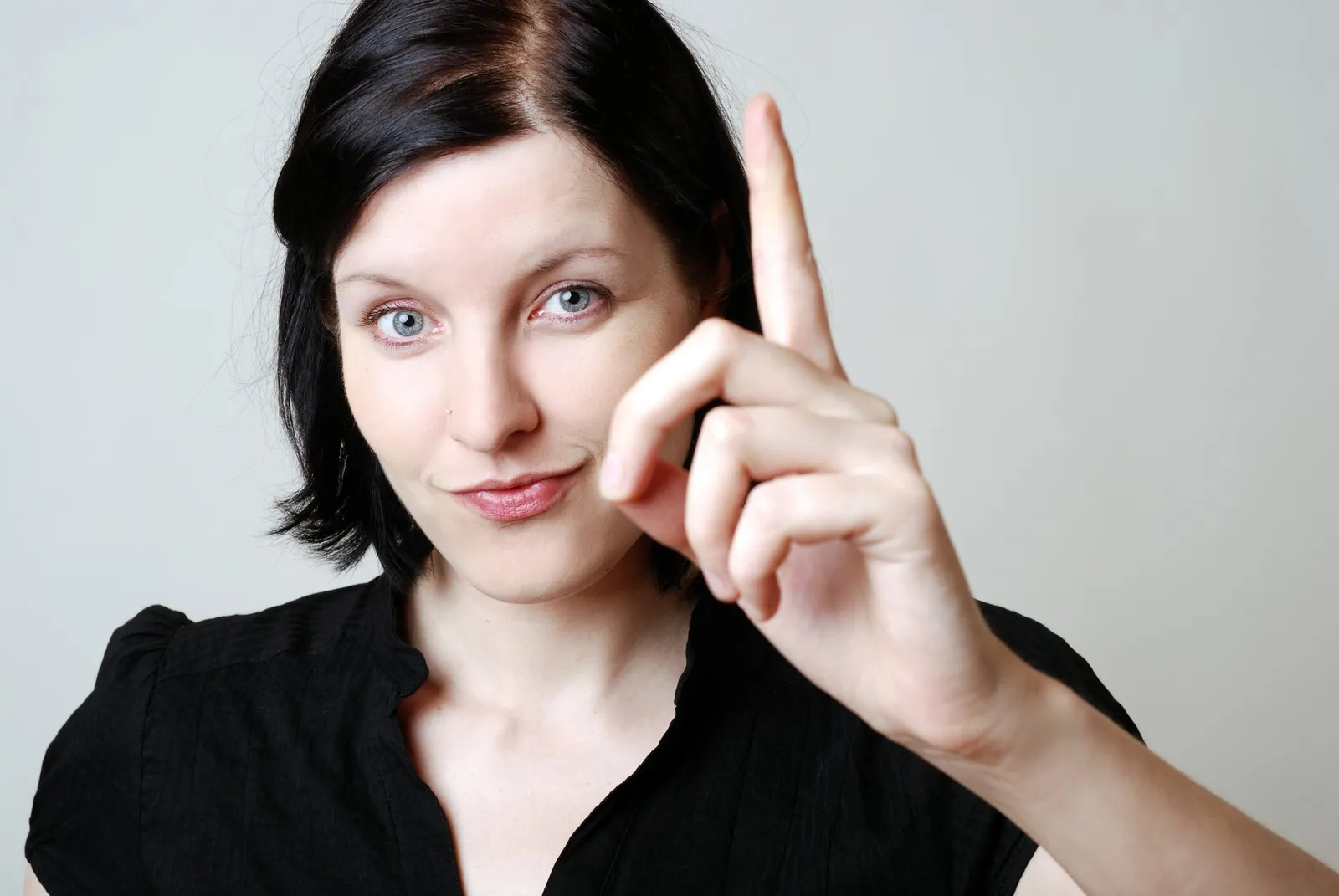 Frau erhebt ihren Zeigefinger.