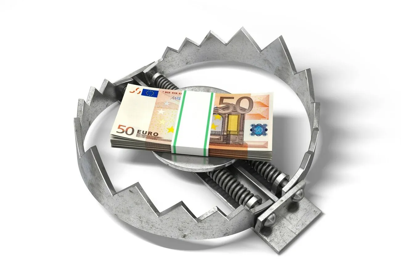 Eine geöffnete Fangeisen-Falle mit einem Bündel 50-Euro Scheine in der Mitte.