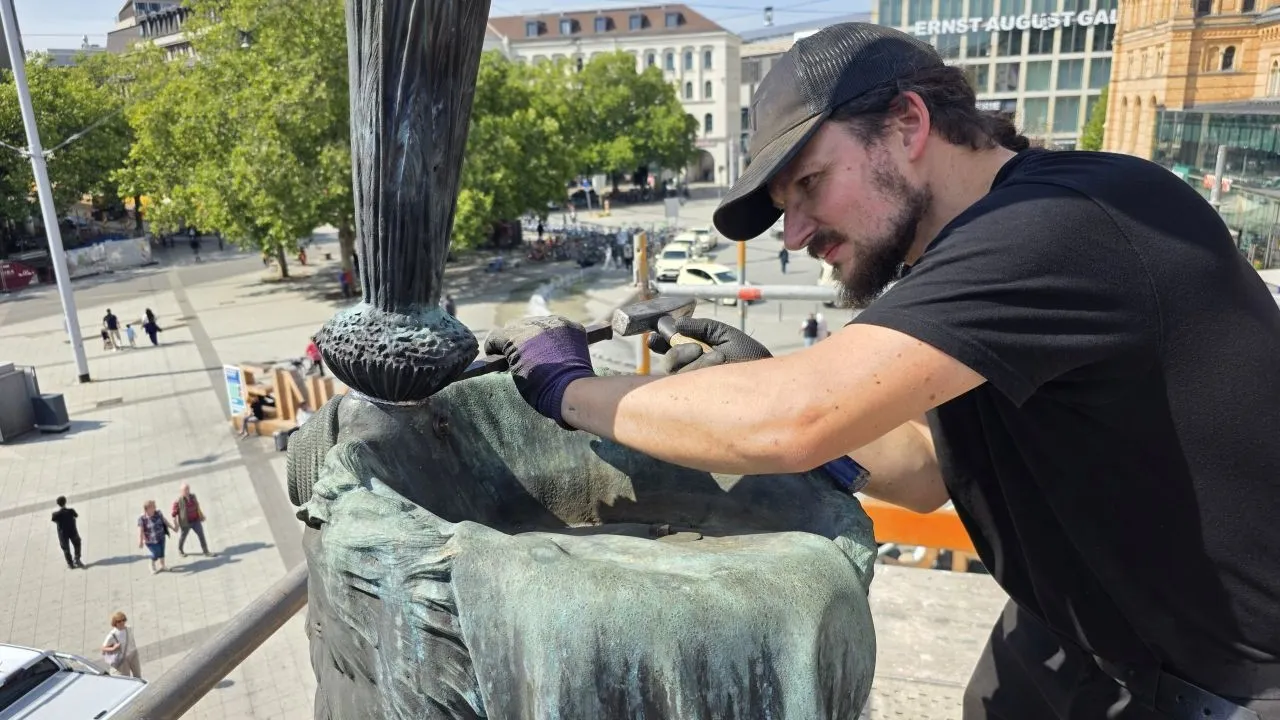 Jungmeister Matthies Wesche beim Verstemmen der Bleieinfassung des Federbusches bei der Wiedermontage