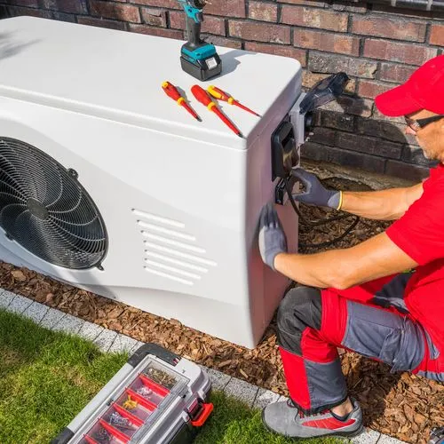 Ein Handwerker baut eine Wärmepumpe ein.